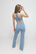 Woman wearing a light blue athletic outfit on a white background