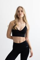 Woman wearing a black athletic outfit on a white background