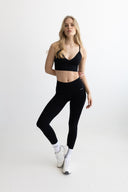 Woman wearing a black athletic outfit on a white background